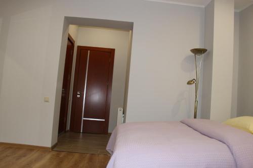 a bedroom with a bed and a brown door at Boutique Hotel 32 in Batumi