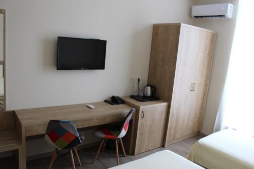 a room with a desk and a tv on a wall at Boutique Hotel 32 in Batumi