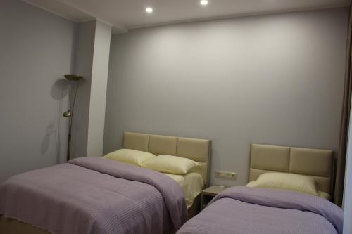 two beds in a room with purple blankets at Boutique Hotel 32 in Batumi