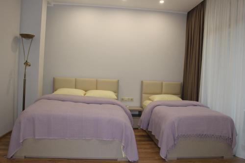 two beds in a room with purple blankets at Boutique Hotel 32 in Batumi