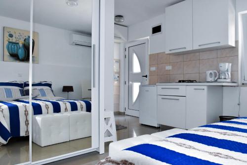 カシュテラにあるApartment AneMare Kastela ~ Near by Split and Trogirの白と青のベッドルーム(ベッド2台付)、キッチンが備わります。
