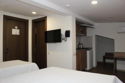 a hotel room with two beds and a flat screen tv at Boutique Hotel 32 in Batumi