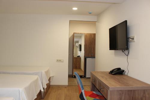 a bedroom with a bed and a tv on a wall at Boutique Hotel 32 in Batumi