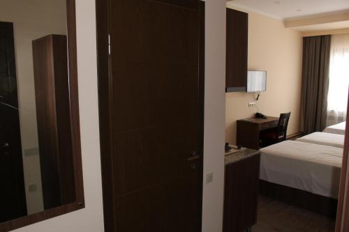 a bedroom with a bed and a door with a mirror at Boutique Hotel 32 in Batumi