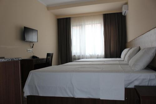 a bedroom with a large white bed with a window at Boutique Hotel 32 in Batumi