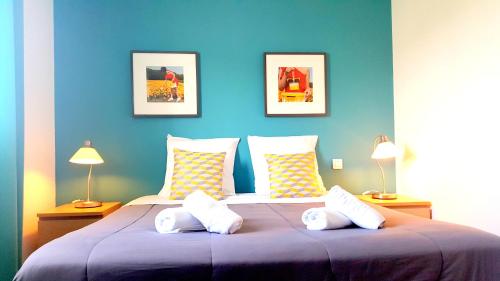a blue bedroom with a large bed with pillows at Hotel Sable Et Soleil - Port, Plage et spa in Fréjus