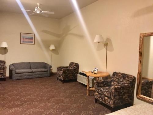 a living room with a couch and chairs and a table at Super 8 by Wyndham Bridgeview of Mackinaw City in Mackinaw City