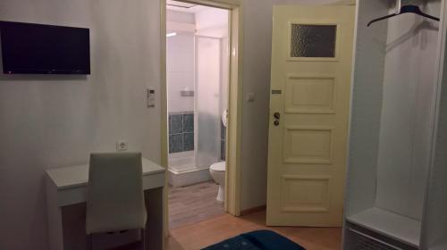 a bathroom with a toilet, sink, and door at Casa Dom Manoel in Portalegre