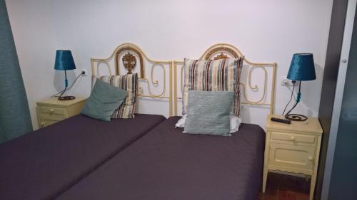 a bedroom with a bed and two night stands with lamps at Casa Dom Manoel in Portalegre
