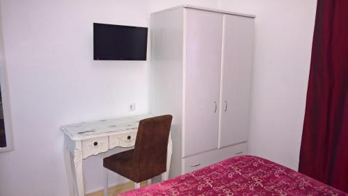 a bedroom with a desk with a chair and a cabinet at Casa Dom Manoel in Portalegre