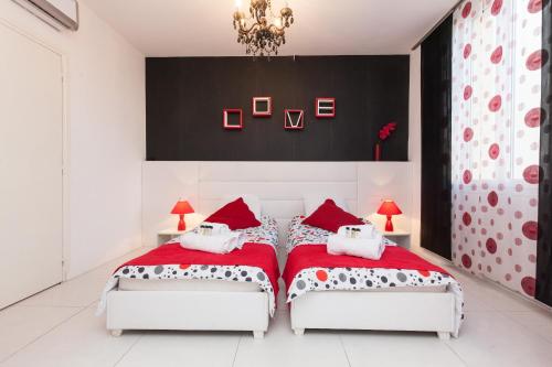 - deux lits dans une chambre rouge et blanche dans l'établissement 7e Art 2 pièces 3 étoiles calme plein centre Cannes 5mn plages et Palais, à Cannes