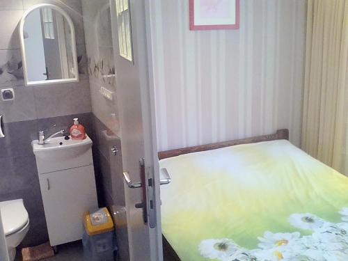 uma pequena casa de banho com uma cama e um lavatório em Dom Gościnny "BASIA" em Jastrzebia Gora