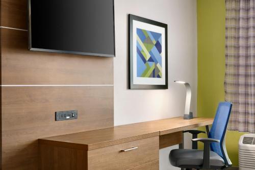a room with a desk with a tv and a chair at Holiday Inn Express & Suites Salisbury by IHG in Salisbury