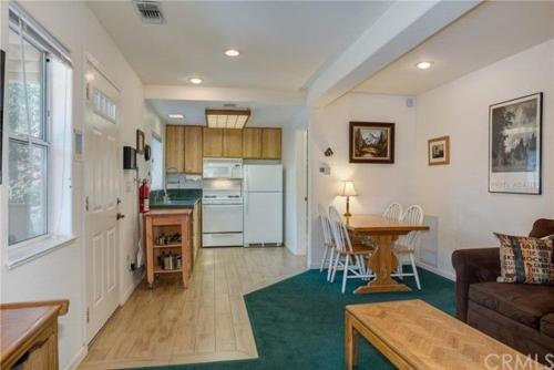 a living room with a couch and a table and a kitchen at Jumping Deer in Yosemite West