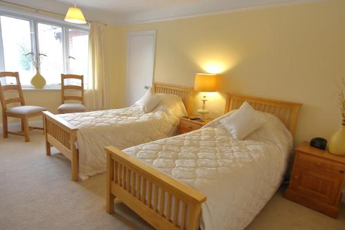 a bedroom with two beds and a chair and a window at Bawdsey Hall in Bawdsey