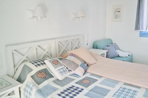 a bedroom with a bed with a quilt and a chair at Annio studios in Plaka