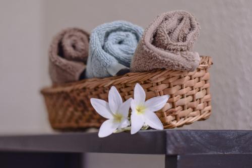a basket with towels and a flower on a shelf at SeaScape Roatan in West End