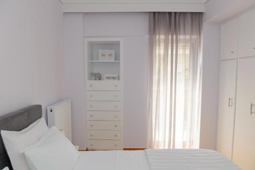- une chambre avec un lit, une commode et une fenêtre dans l'établissement Grey Suite Filoxenia, à Thessalonique