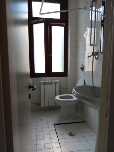 Calle Rielo great canal view في البندقية: حمام مع مرحاض ومغسلة ونافذة