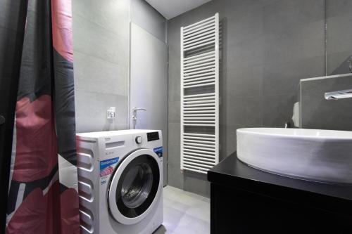 a bathroom with a washing machine next to a sink at Amazing Penthouse old town in Sarajevo