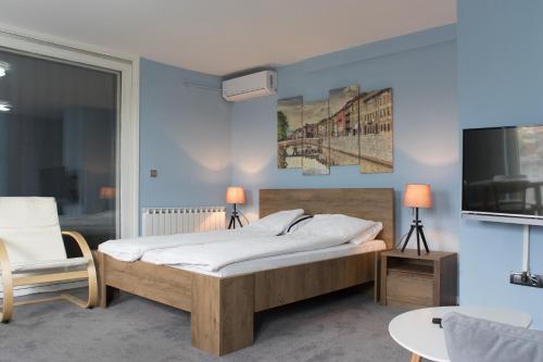 a bedroom with a bed and a tv and a chair at Amazing Penthouse old town in Sarajevo