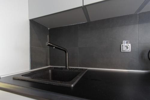 a black sink with a faucet in a bathroom at Amazing Penthouse old town in Sarajevo