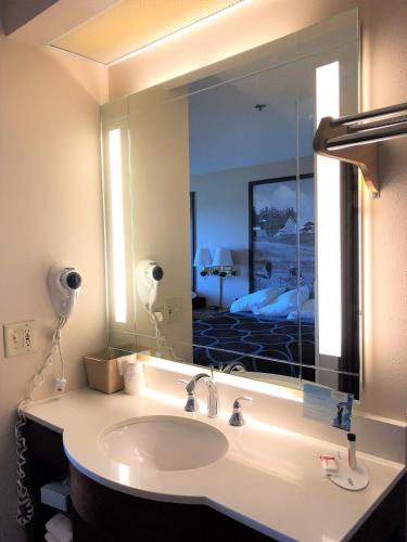 a bathroom with a sink and a large mirror at Super 8 by Wyndham Dodgeville in Dodgeville