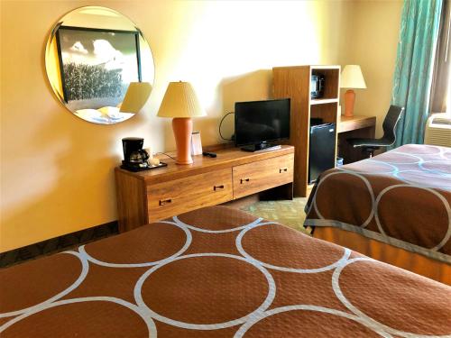 a hotel room with a bed and a mirror at Super 8 by Wyndham Dodgeville in Dodgeville