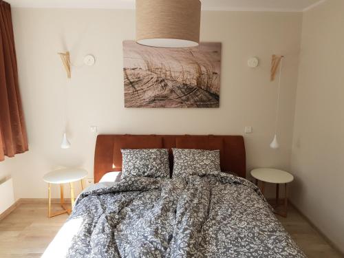 a bedroom with a bed and two tables at Nida like home in Nida