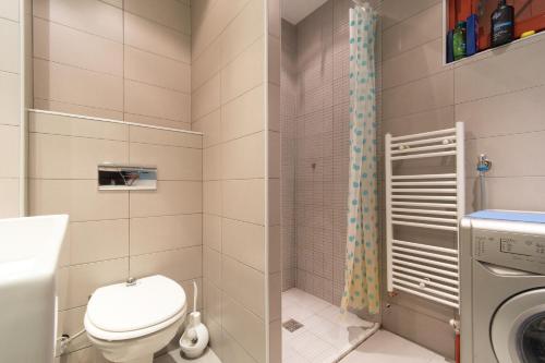a bathroom with a toilet and a washing machine at Amazing Penthouse old town in Sarajevo