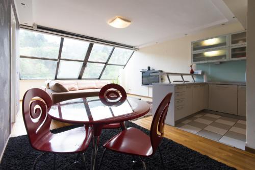 a living room with a table and a kitchen at Amazing Penthouse old town in Sarajevo