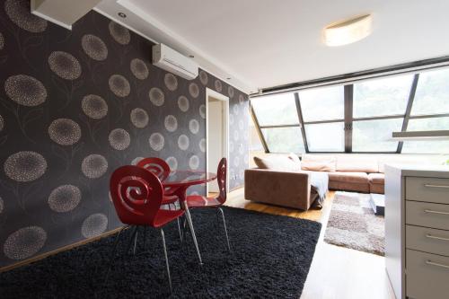 a living room with a red chair and a table at Amazing Penthouse old town in Sarajevo
