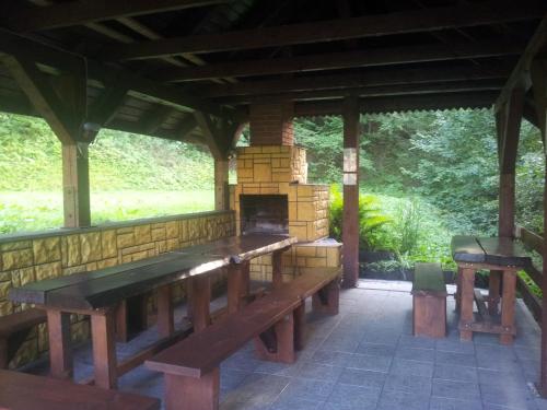 a pavilion with wooden benches and a fireplace at CIME Ekonomik in Brenna