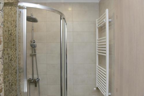 y baño con ducha y puerta de cristal. en Grey Suite Filoxenia, en Tesalónica