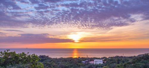 a sunset over the ocean with the sun setting at SeaScape in West End