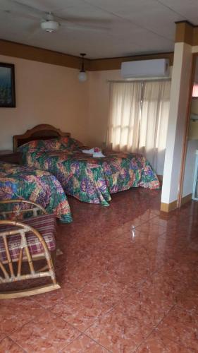 a room with two beds and a room with at Cabinas Doña Alicia in Quepos