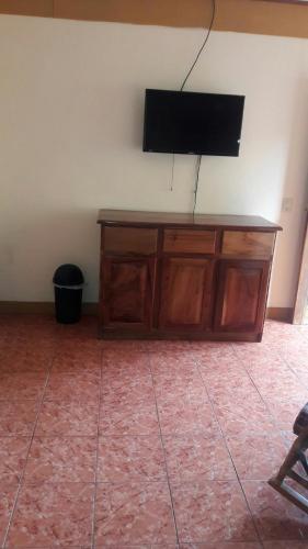 a flat screen tv on top of a wooden cabinet at Cabinas Doña Alicia in Quepos