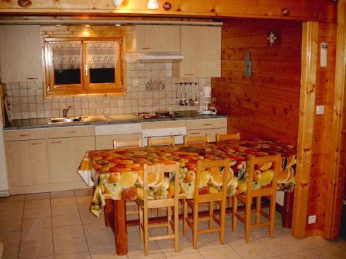 una cocina con mesa y sillas. en Chalet Helalph, en La Bresse