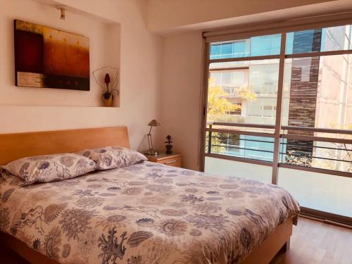 1 dormitorio con cama y ventana grande en Departamento Arquimedes 214 - 503, en Ciudad de México