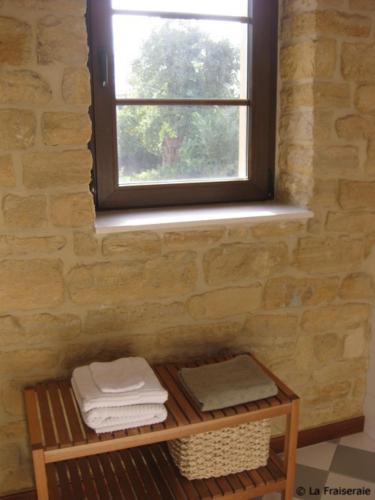 a bathroom with a window and a shelf with towels at Chambres d'Hôtes La Fraiseraie in Tellancourt