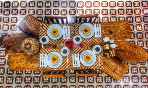 a wooden table with plates of food on it at Casa de Zari in Campeche