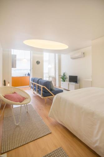 a bedroom with a bed and a couch and a table at Republica Apartments at D. Luis I Bridge in Vila Nova de Gaia