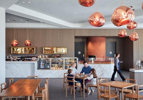 a group of people sitting at a table in a restaurant at RACV Cape Schanck Resort in Cape Schanck