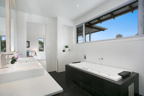 a bathroom with two sinks and a large bath tub at The Lotus in Gold Coast