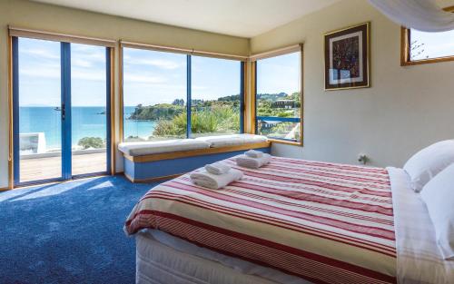 a bedroom with a bed with a view of the ocean at Palm Beach Lodge in Palm Beach