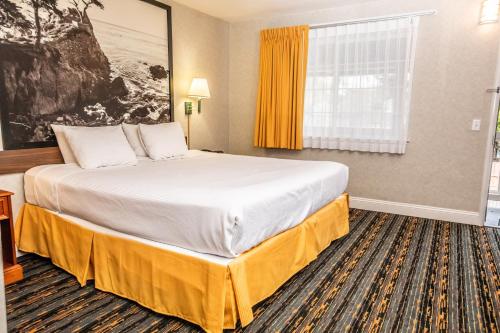 a hotel room with a large bed and a window at Pelican Inn in Monterey