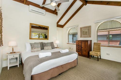 a bedroom with a large bed and a window at The Terraces Main Beach in Byron Bay