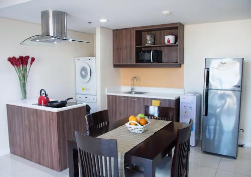 a kitchen with a table with a bowl of fruit on it at Alicia Apartelle in Cebu City