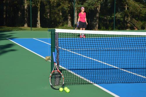 a woman is standing on a tennis court at OM B&B + Spa in Viamão