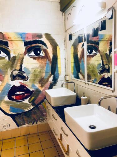 a bathroom with a painting of a woman on the wall at Beachside Backpackers in Port Macquarie